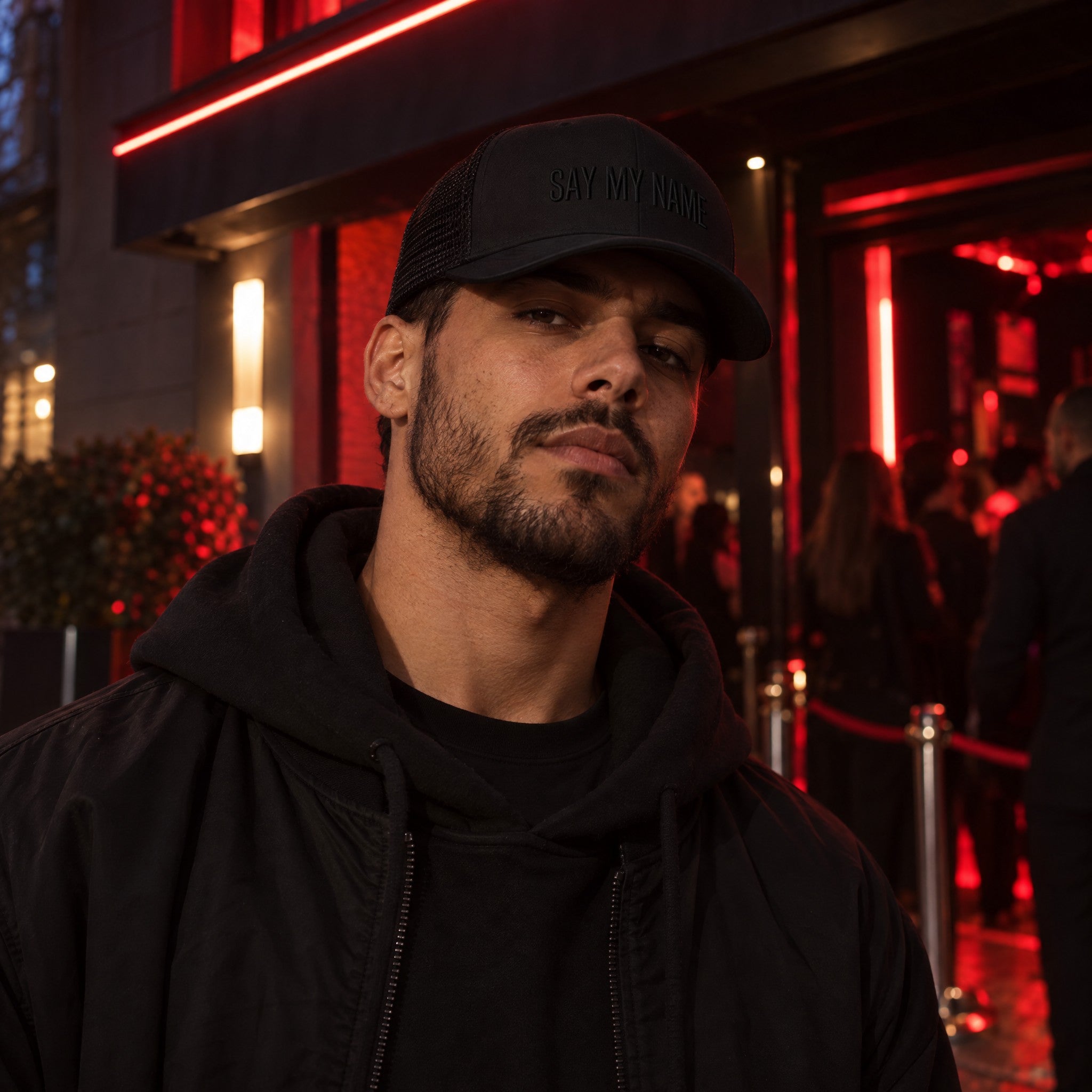 Casquette BLACK NOIR SAY MY NAME portée devant un club la nuit