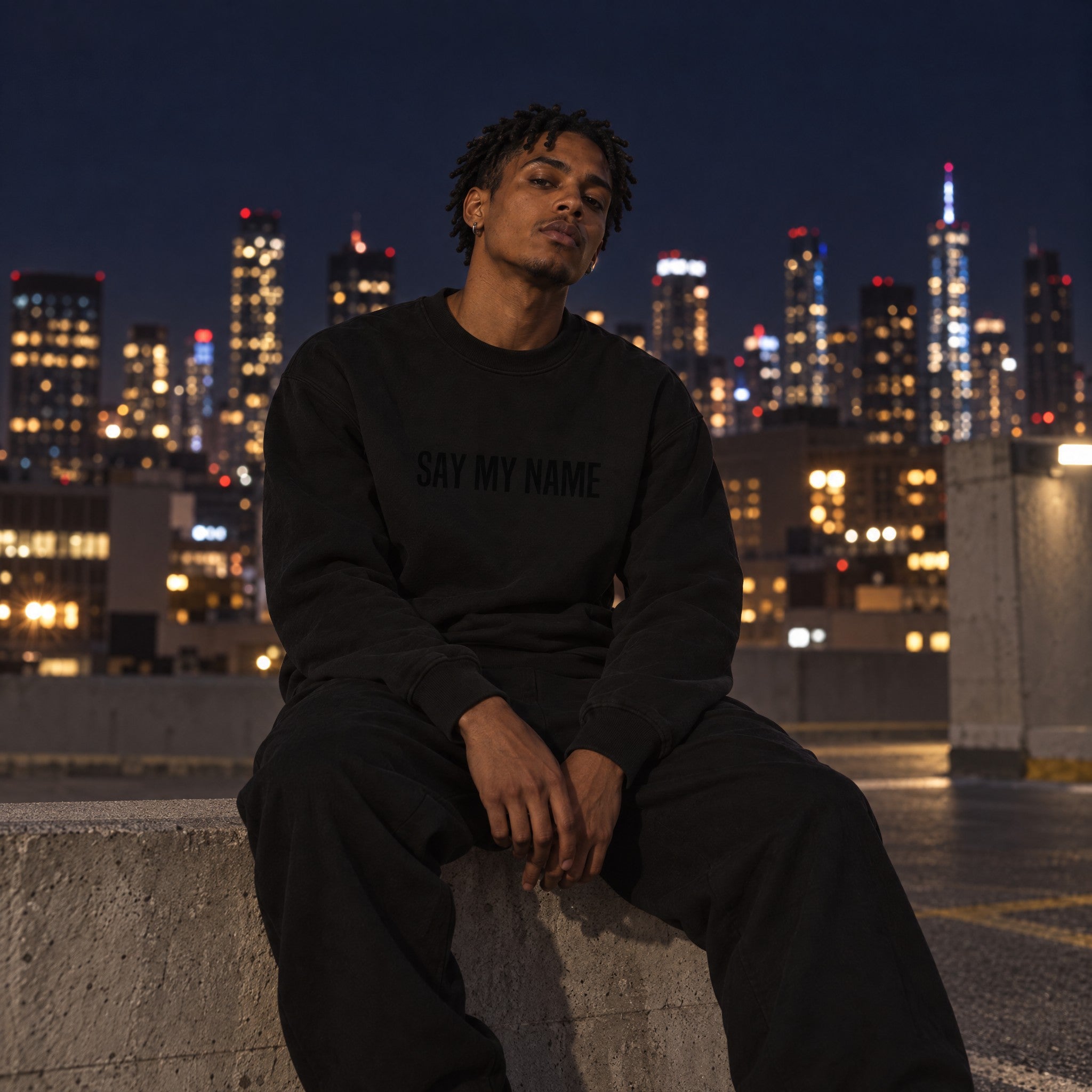 Sweatshirt BLACK NOIR SAY MY NAME by Crazy Sir-G porté sur un rooftop la nuit